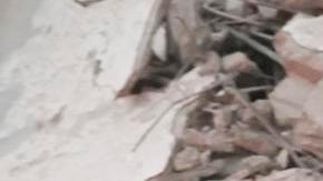 Los servicios de emergencia transportan el cuerpo de una víctima entre los escombros de un edificio residencial parcialmente destruido tras un ataque aéreo israelí.