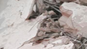 Los servicios de emergencia transportan el cuerpo de una víctima entre los escombros de un edificio residencial parcialmente destruido tras un ataque aéreo israelí.