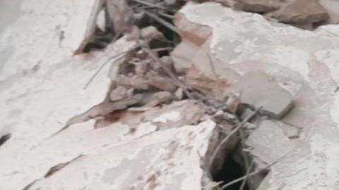 Los servicios de emergencia transportan el cuerpo de una víctima entre los escombros de un edificio residencial parcialmente destruido tras un ataque aéreo israelí.