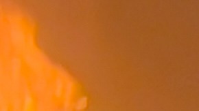 Un bombero extingue el fuego de un automóvil en el lugar de los ataques aéreos.