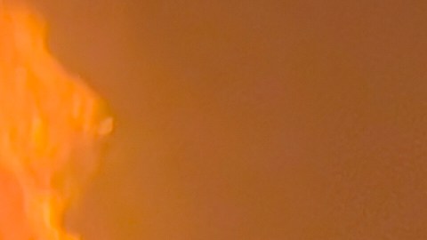 Un bombero extingue el fuego de un automóvil en el lugar de los ataques aéreos.