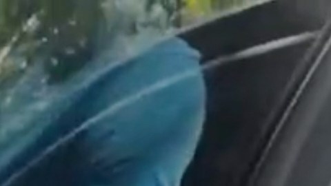 En esta imagen, extraída de un vídeo grabado con la cámara corporal de un agente de policía y difundido por la Oficina del Sheriff del Condado de Martin, Florida, el golfista Tiger Woods aparece sentado en un vehículo policial sin distintivos mientras habla con agentes de la ley tras un accidente de coche en Jupiter Island, Florida, el viernes 27 de marzo de 2026.