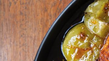 Muslos de pollo con piel crujiente bañados en aderezo de chile guajillo y acompañados de tomatillos asados al punto exacto de caramelización.