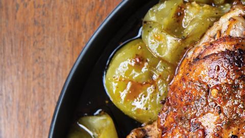 Muslos de pollo con piel crujiente bañados en aderezo de chile guajillo y acompañados de tomatillos asados al punto exacto de caramelización.