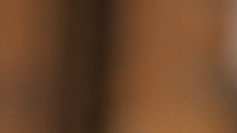 Un vaso de café y una taza de café de Dunik sobre una mesa de una cafeteria.