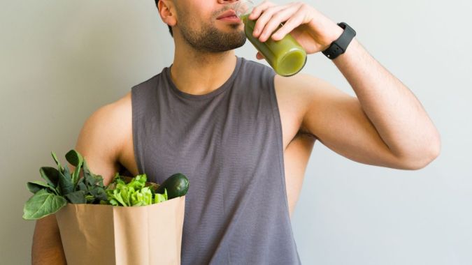 Hombre bebiendo un jugo verde.