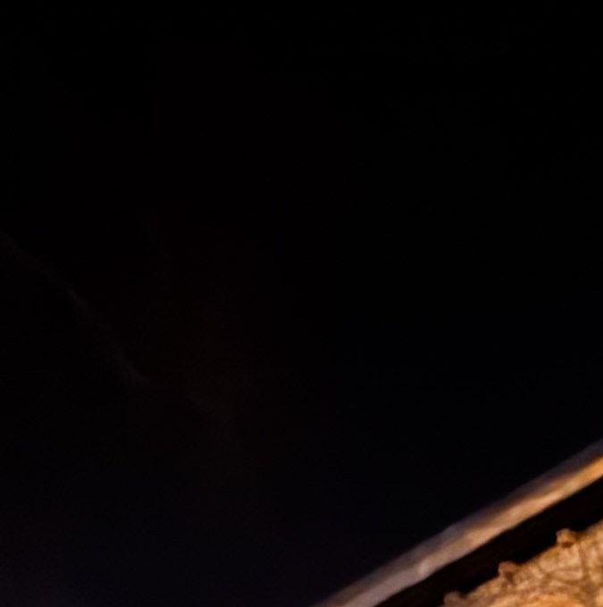 Fachada nocturna del centro cultural Conne Island en Connewitz, Leipzig, con grafitis "Barrio Antifascista" y "Antifa" sobre los muros.