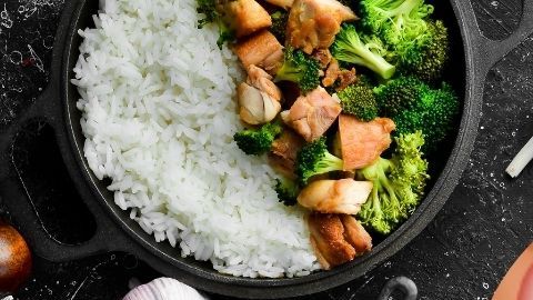 Frutas, verduras y vegetales sobre fondo negro con una imagen de un pancreas.