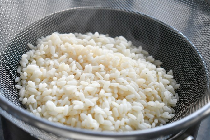 Arroz blanco sobre un colador de cocina