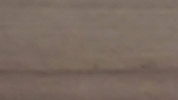 El detalle senital de una mujer con las piernas cruzadas en la mano un reloj y el otra una ensalada y una cinta métrica en el piso.