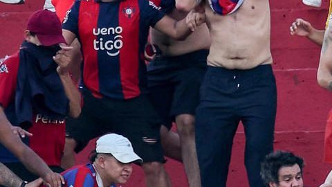 Fotografía cedida por Derlis Martínez que muestra a aficionados de Cerro Porteño enfrentándose con la Policía de Paraguay durante el juego entre Olimpia y Cerro Porteño este domingo, en el estadio Defensores del Chaco, en Asunción.