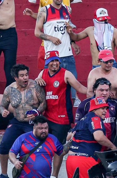 Fotografía cedida por Derlis Martínez que muestra a aficionados de Cerro Porteño enfrentándose con la Policía de Paraguay durante el juego entre Olimpia y Cerro Porteño este domingo, en el estadio Defensores del Chaco, en Asunción.