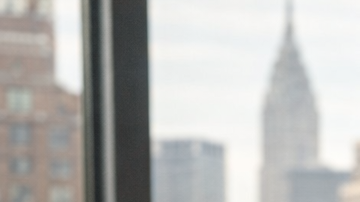 Pareja latina sentada en una cama mirando un calendario mientras planifica la búsqueda de embarazo en casa