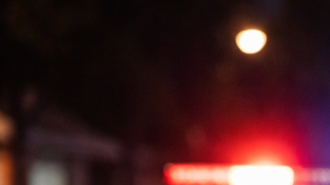 Hombre latino detenido en un control policial nocturno en Estados Unidos con luces de patrulla