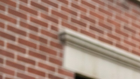Familia latina frente a un edificio de apartamentos en Nueva York revisando opciones de alquiler, reflejando la dificultad para acceder a vivienda asequible.