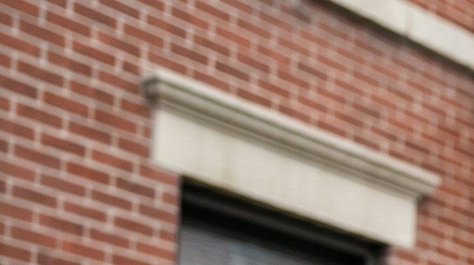 Familia latina frente a un edificio de apartamentos en Nueva York revisando opciones de alquiler, reflejando la dificultad para acceder a vivienda asequible.