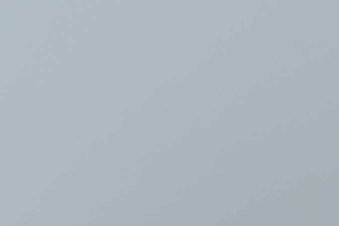 Detalle de un hombre vestido de blanco con una figura de un riñón a un lado.