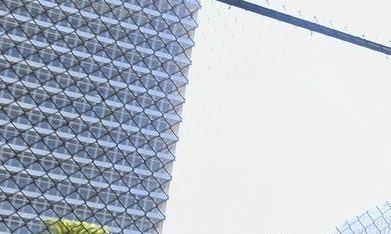 Un hombre sin hogar traslada sus pertenencias por una calle llena de carpas.