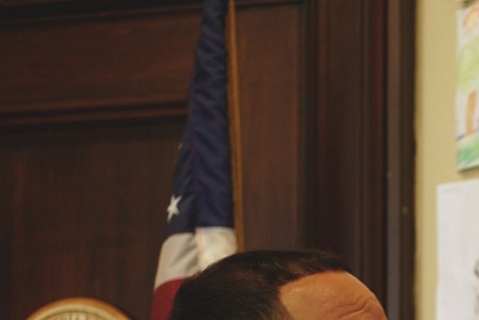Joshua A. García señala placas con los colores de Puerto Rico e Irlanda en su oficina del ayuntamiento de Holyoke.