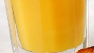 Desayuno tradicional con huevos revueltos, pa tostado, jugo de naranja y café con una figura de dos riñones el lado derecho.