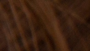 Una composición con una melena de cabello, un frasco con aceite de oliva, aceitunas y hojas de oliva,