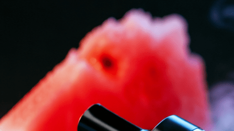 Cigarrillo electrónico con vapor rodeado de frutas y dulces que representan los sabores atractivos de los vapes
