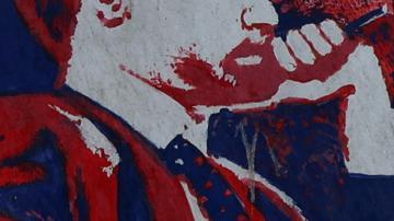 Una mujer iraní pasa junto a un mural antiestadounidense (que representa una mesa de negociación entre Irán y Estados Unidos) junto a la antigua embajada de Estados Unidos en Teherán, Irán, el 22 de junio de 2026.