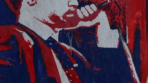 Una mujer iraní pasa junto a un mural antiestadounidense (que representa una mesa de negociación entre Irán y Estados Unidos) junto a la antigua embajada de Estados Unidos en Teherán, Irán, el 22 de junio de 2026.