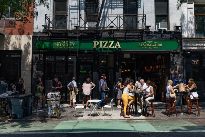 Una calle de Nueva York donde hay una pizzería