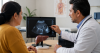 Médico explicando una ecografía hepática a una paciente durante una consulta médica