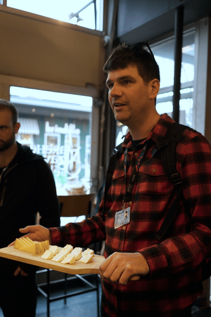 El guía Chris Erb presenta una tabla de quesos de Quebec durante un recorrido por el mercado Jean-Talon