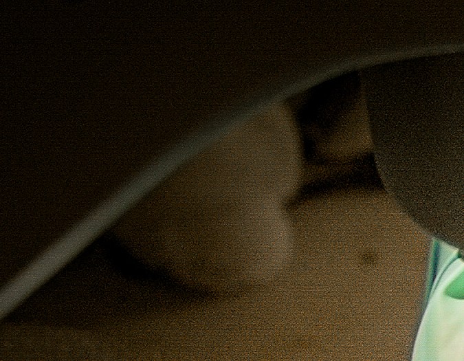 Close-up of gloved hands working with a tool on a small object, possibly in a laboratory or workshop setting.