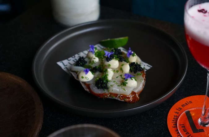 Tostada de vieira cruda con salsa macha, caviar, crema y flores de borraja en Bar Luz, Montreal