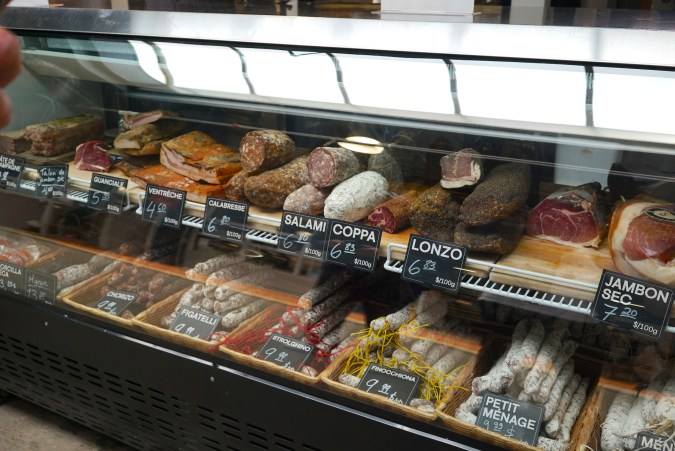 itrina de charcutería en el mercado Jean-Talon con jamones, salami, coppa, lonzo y chorizo curados