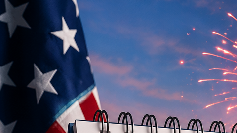 Calendario marcado en el 4 de julio con la Estatua de la Libertad, el skyline de Nueva York y fuegos artificiales al atardecer.