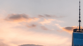 Miles de aficionados ven un partido del Mundial en una pantalla gigante frente al skyline de Nueva York al atardecer