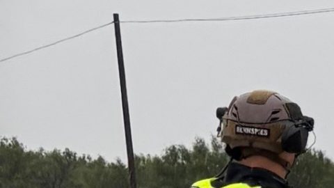 Se observa a un guardabosques caminando entre las aguas crecidas por las fuertes lluvias en el condado de Uvalde, Texas.