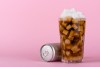 Un vaso de gaseosa con muchos cubos de azúcar