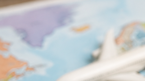 Varios pasaportes sobre un mapa mundial junto a una brújula y un avión, como representación del ranking de movilidad internacional de 2026.