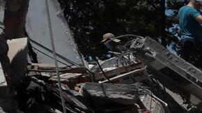 Personas buscan entre los escombros de una edificación colapsada por el terremoto de magnitud 7,4 que sacudió al país, este lunes en Cali (Colombia).