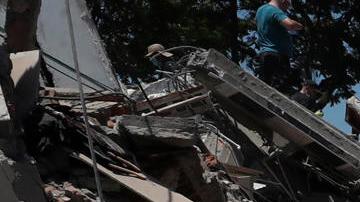 Personas buscan entre los escombros de una edificación colapsada por el terremoto de magnitud 7,4 que sacudió al país, este lunes en Cali (Colombia).