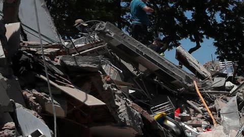 Personas buscan entre los escombros de una edificación colapsada por el terremoto de magnitud 7,4 que sacudió al país, este lunes en Cali (Colombia).