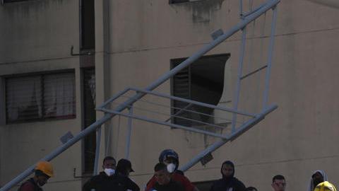 Personas trabajan en labores de rescate en una edificación colapsada por el terremoto de magnitud 7,4 que sacudió al país este lunes, en Cali (Colombia).
