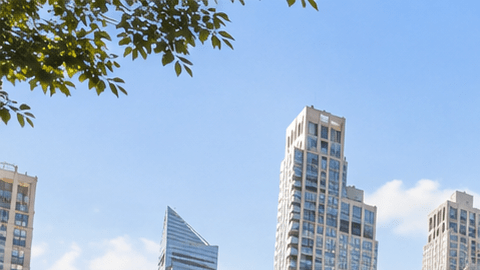 Edificio residencial moderno en Manhattan, Nueva York, con apartamentos y balcones en una calle arbolada.