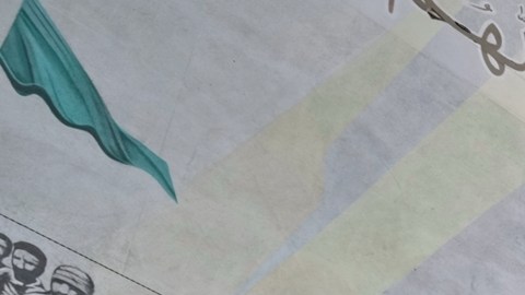 Un clérigo chiíta armado frente a una valla que muestra al ayatolá Ruhollah Khomeini, fundador de la República Islámica.