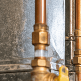 Técnico repara un sistema de calefacción en Nueva York, en una imagen sobre la ayuda para calefacción en Nueva York de hasta $8,000 mediante HEAP para reparar o reemplazar equipos.